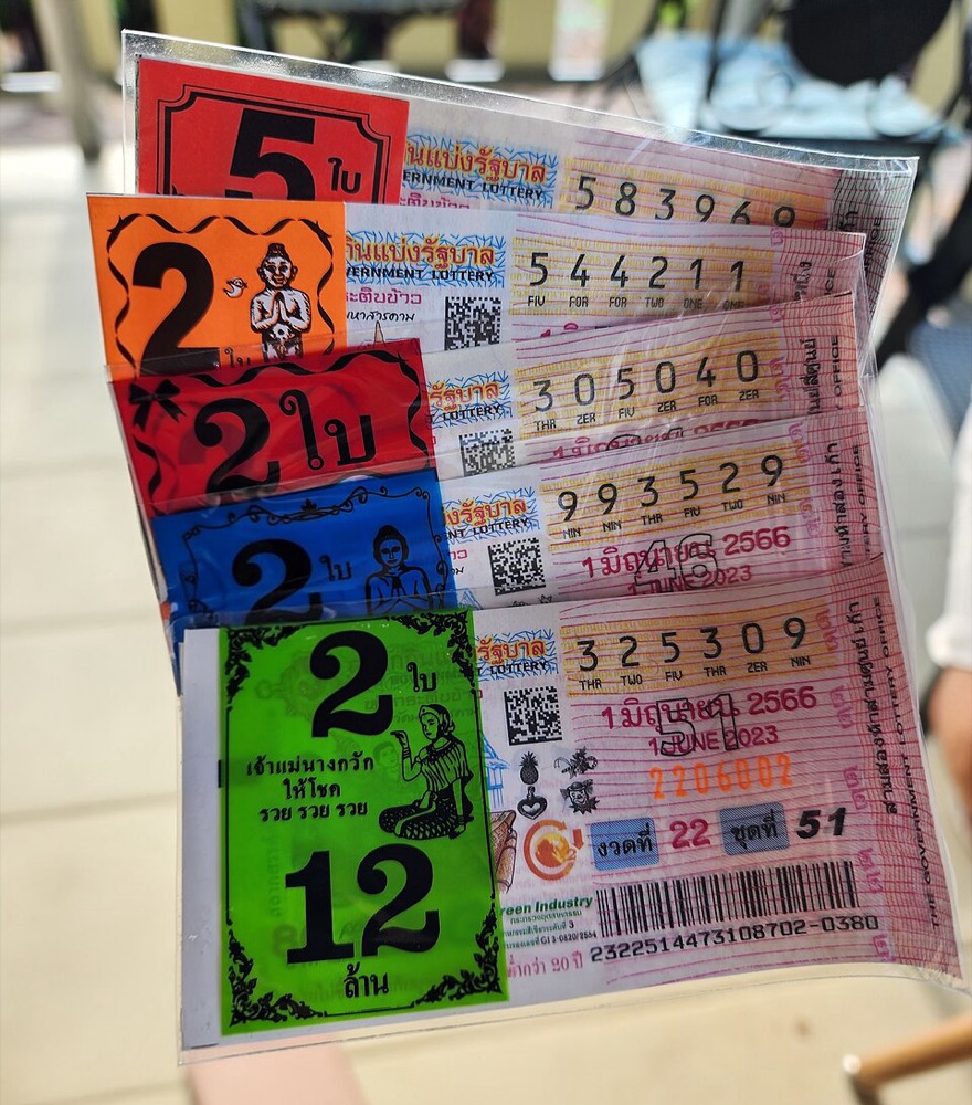 ใบสลากกินแบ่งรัฐบาลไทยหลายใบ เห็นเลข 6 หลัก QR code และบาร์โค้ดบนใบสลาก